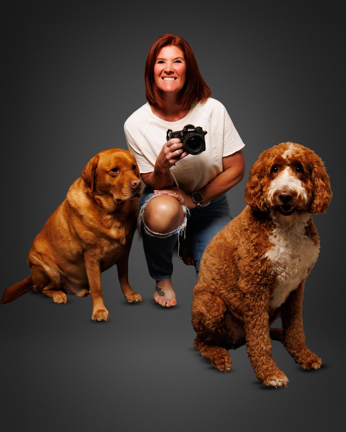 Amy Scotti kneeling with her camera between her lab Riggs and her goldendoodle Goofy