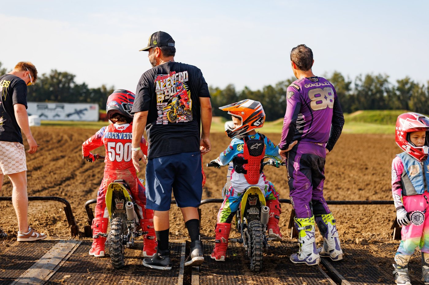 Young riders and their dads lined up at the starting gate before a race